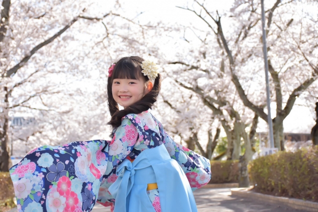 袴を着て桜並木で振り返る女の子