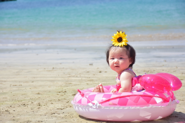 浜辺で浮き輪の中に座る赤ちゃん
